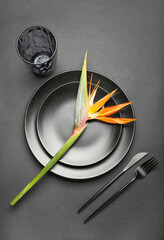 Simple table setting with bird of paradise flower on dark background