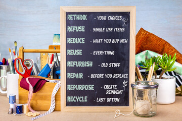 R's of sustainable waste management on chalkboard placed on workshop bench with tools and materials for repair, repurpose, refurbish and reducing household waste