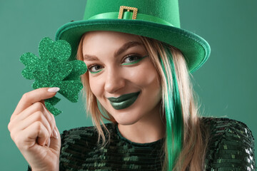 Beautiful woman with decorative clover on green background, closeup. St. Patrick's Day celebration