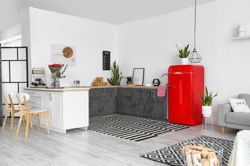 Interior of modern kitchen with counters and red fridge