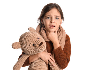 Little girl with toy suffering from sore throat on white background