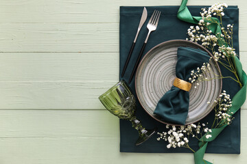 Stylish table setting with flowers on green wooden background