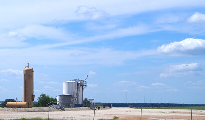 Obraz premium Crude oil storage tanks on a pad in a farm pasture 