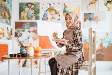 muslim asian female artist painting on canvas