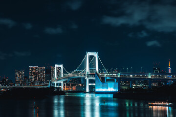 Fototapeta premium Rainbow bridge in Odaiba, with Tokyo city lights in the background