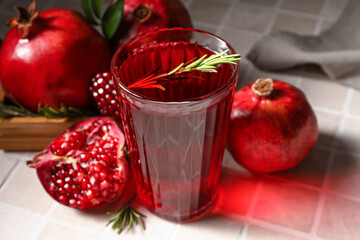 Glass of delicious pomegranate juice on tile background