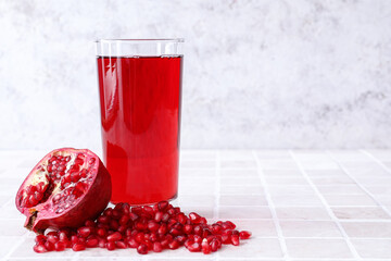 Glass of delicious pomegranate juice on table