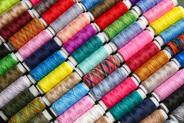 Spools with colorful sewing threads as background