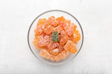 Glass bowl with tasty jelly bears on light background