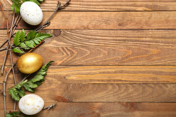 Obraz na płótnie Canvas Composition with beautiful Easter eggs, tree branches and fern leaves on wooden background