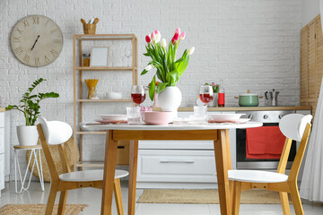 Dining table with stylish setting for International Women's Day celebration in light kitchen