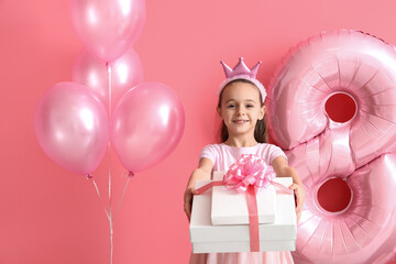 Little girl with gift boxes and balloons on pink background. International Women's Day celebration