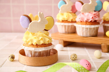 Tasty Easter cupcake and eggs on color background, closeup