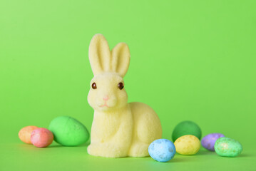 Cute Easter bunny and eggs on green background