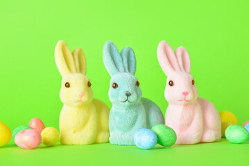 Cute Easter bunnies and eggs on green background
