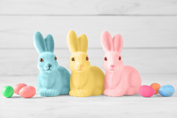 Cute Easter bunnies with eggs on light background
