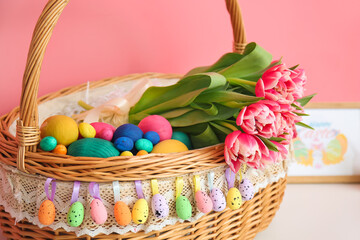 Fototapeta na wymiar Wicker basket with Easter eggs and flowers, closeup