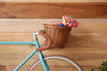 Fototapeta na wymiar Bicycle with Easter basket on wooden background
