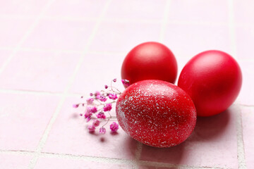 Beautiful Easter eggs and flowers on color tile, closeup