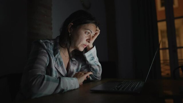 Person reading content online at night in front of laptop screen