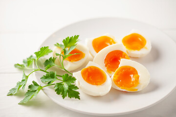 Boiled eggs  with parsley leaves  in a plate on a gray background.