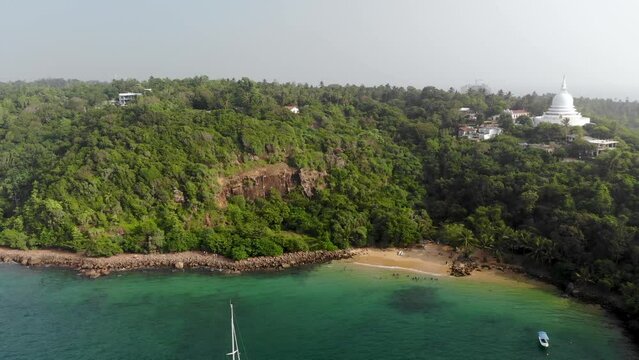 Aerial view of an ocean bay with mountains and Buddhist temple in Sri Lanka