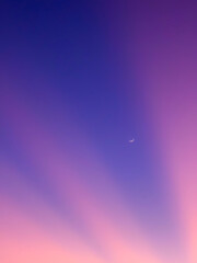 Moon against purple sunset streaks