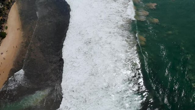 Vertical aerial view of Indian ocean waves and coast in Sri Lanka