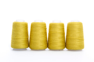 Yellow spool of thread isolated on white background. Skein of woolen threads. Yarn for knitting. Materials for sewing machine. Coil.