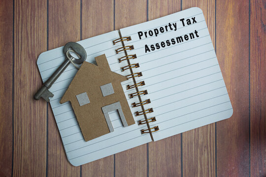 Property tax assessment text on a note book with house model and key