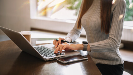 Working Process in Modern Office. Young Woman Account Manager Working at Wood Table with New Business Project. Typing keyboard,Using Contemporary Laptop.
