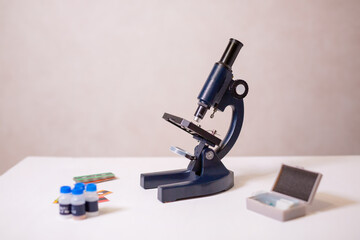 A schoolgirl with a microscope examines chemicals in test tubes, conducts experiments. The concept of coronavirus research in the laboratory