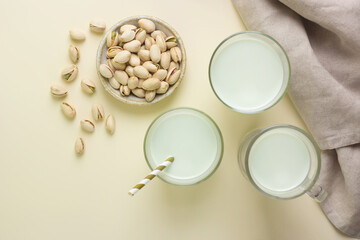 Pistachio milk in different glass cups and pistachios. Top view