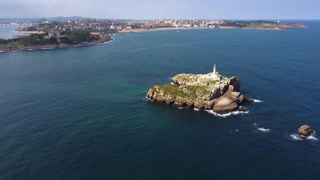 Aerial view of Santander cantabria spain north coastline. Drone fly above lighthouse islet in the middle of the clear ocean water