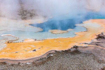 Hot zone of blue and orange minerals in geyser.