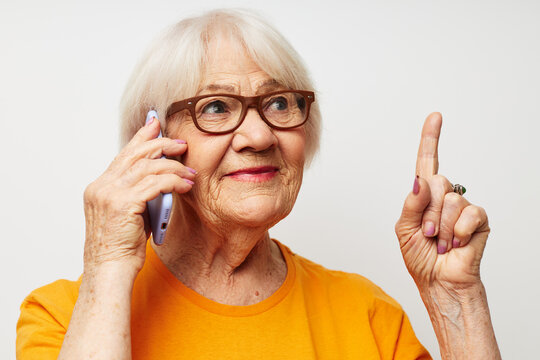 Portrait of an old friendly woman happy lifestyle in yellow t-shirts light background