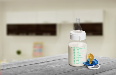Bottles of milk for baby on table in kitchen