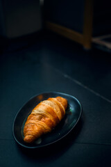 Breakfast with fresh croissants on black dish
