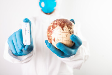 Doctor holding the planet Earth and coronavirus test