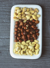 Mixed nuts in a bowl on a gray wooden background