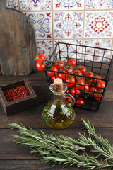 Oil, rosemary, salt, pepper, tomatoes on a wooden table in the kitchen
