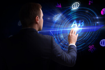 Business, Technology, Internet and network concept. Young businessman working on a virtual screen of the future and sees the inscription: AR
