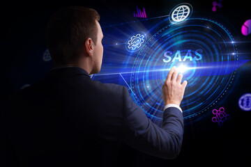 Business, Technology, Internet and network concept. Young businessman working on a virtual screen of the future and sees the inscription: SAAS