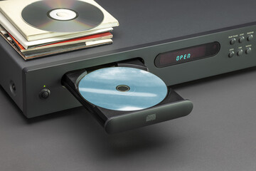 CD player with open tray, close up. Disc, envelopes on the cover of the player.