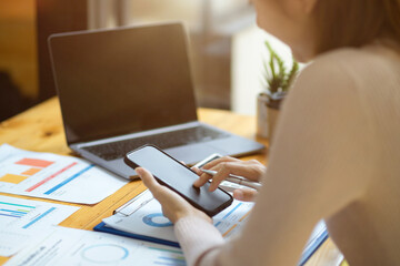 Female accountant using her mobile phone over office desk.