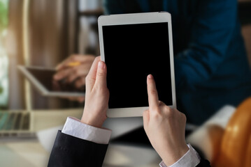 Engineer hand held black tablet with a blank white screen in the office in the morning light.