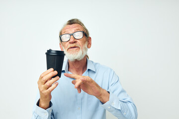 Portrait elderly man with a black glass in his hands a drink isolated background