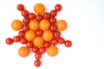 Red and yellow tomatoes stacked on a white table in the form of a star