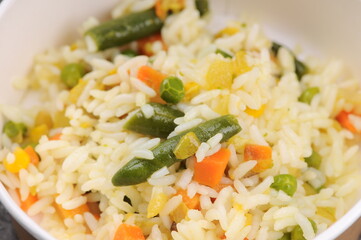 rice with vegetables in a cardboard bowl
