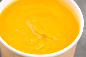 pumpkin cream soup in a cardboard glass
